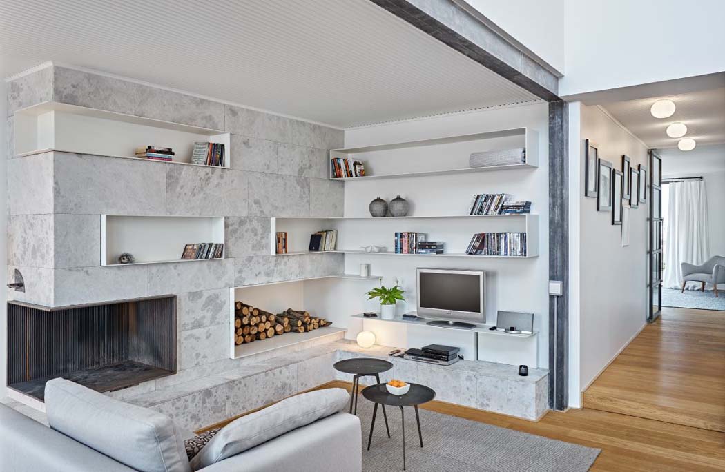 Une bibliothèque en marbre blanc et fabriquée sur mesure fait partie de l’ameublement design aménagement sobre appartement moderne en ville