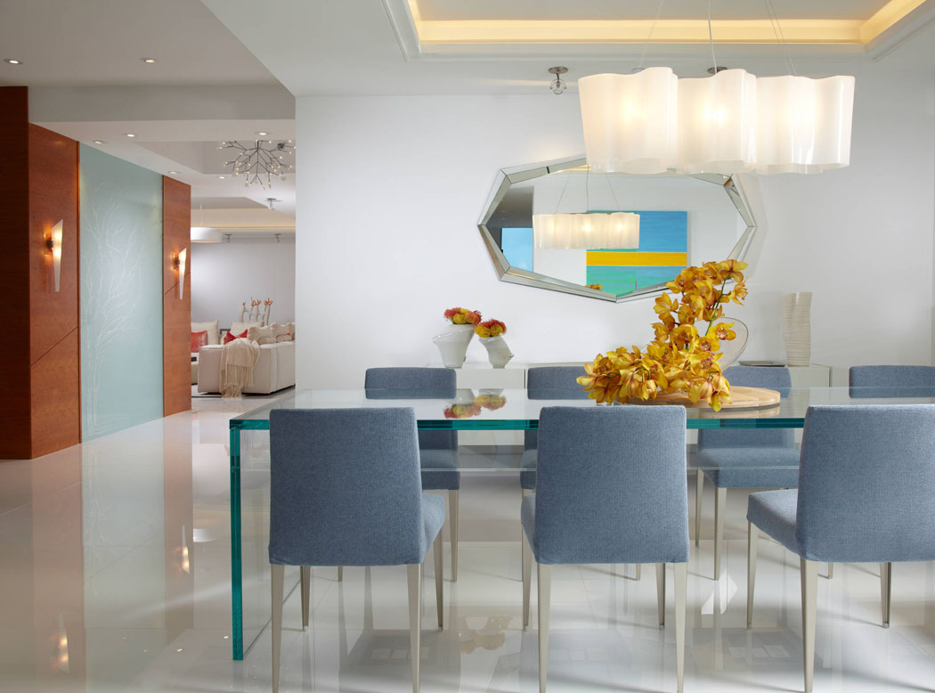 La salle à manger de ce magnifique appartement luxueux dans un blanc étincelant aux plusieurs chaises de design moderne salle à manger ameublement moderne chic