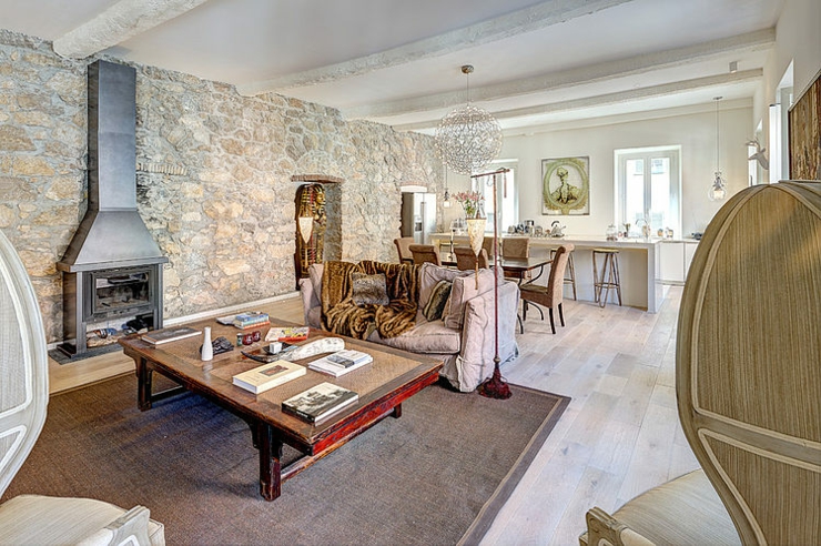 Séjour aux poutres apparentes et aux murs en pierres design ambiance rustique appartement