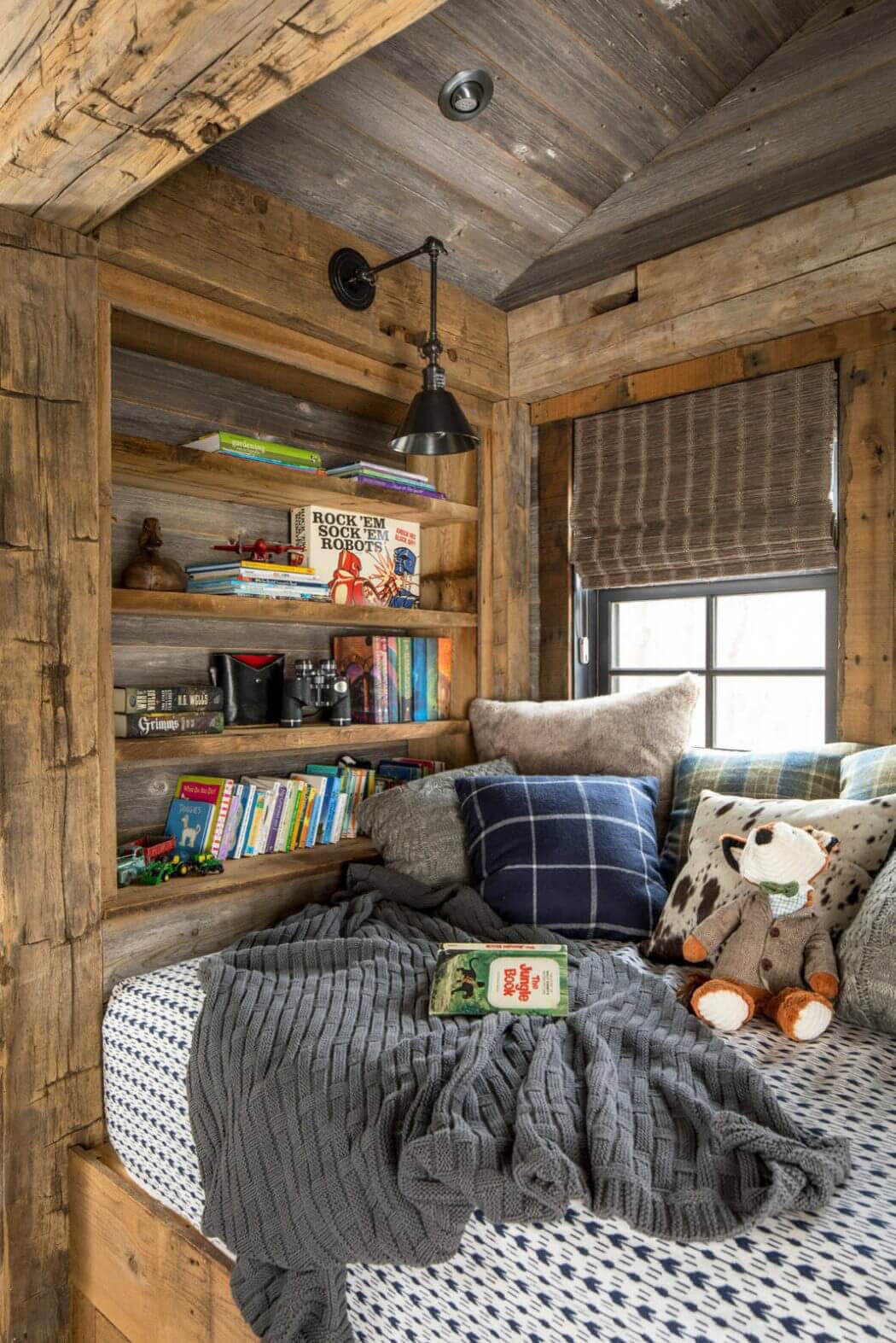 Coin lecture et relaxation avec cette banquette installée près de la fenêtre – l’endroit idéal pour la lecture coin lecture dans les combles maison rustique de vacances