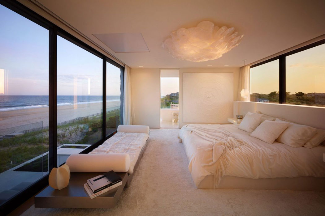 La suite principale avec ses grands murs vitrés, la belle vue sur la plage et la splendide salle de bains privative chambre principale maison de vacances luxe mer
