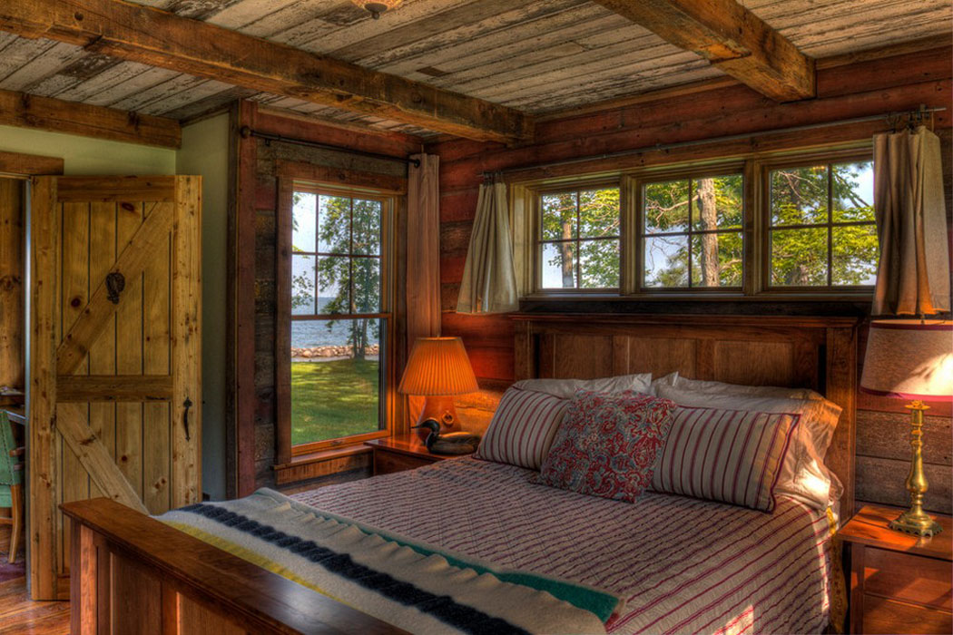 Une des chambres à coucher au rez-de-chaussée de cette maison de vacances petite chambre rustique maison du lac
