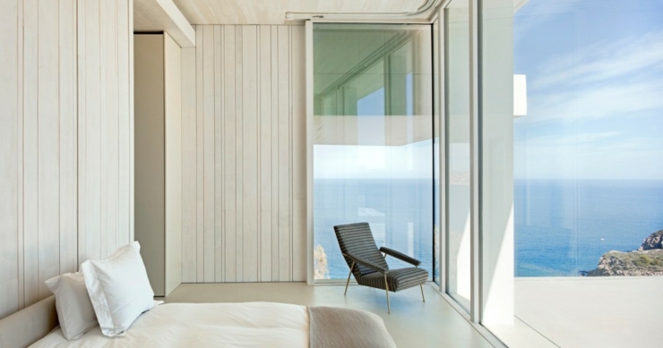 Une des chambres avec son balcon privé et sa vue imprenable sur l’eau intérieur villa vue panoramique sur mer