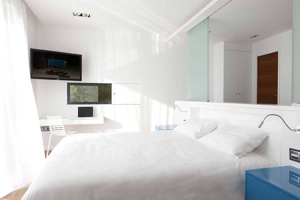 L’une des chambres à coucher de cette jolie maison d’architecte à Monaco chambre à coucher meublée avec vue
