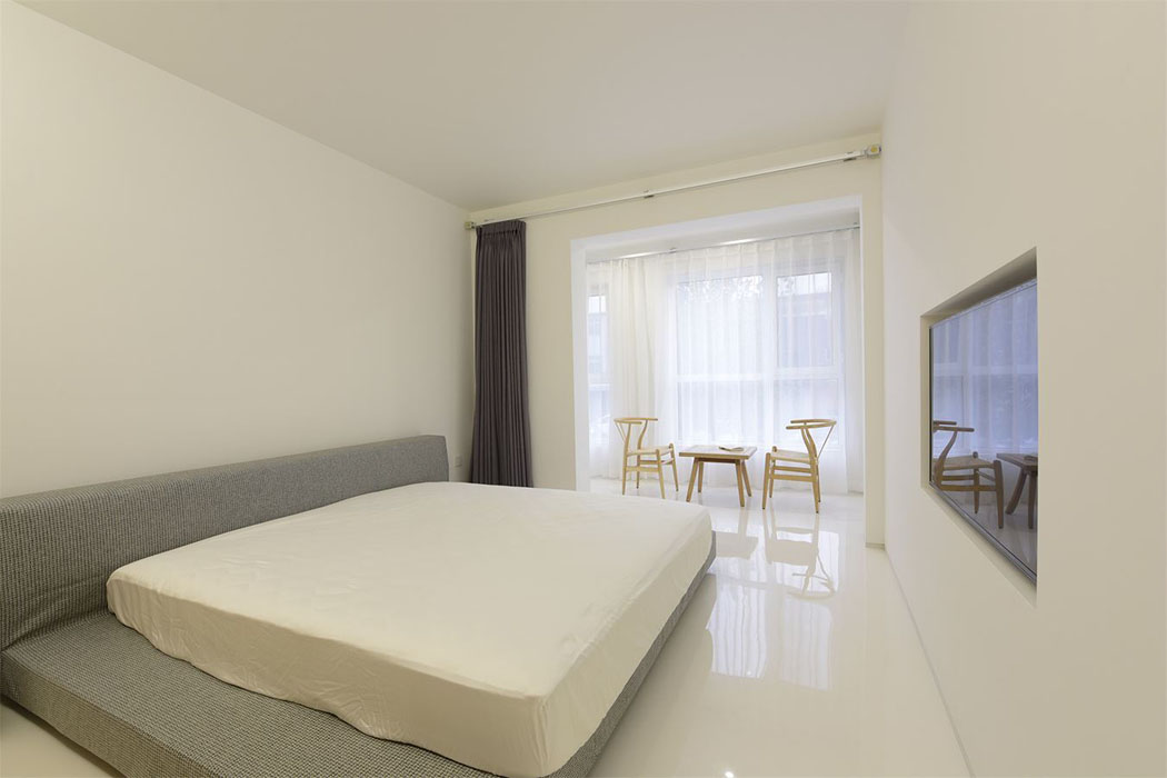 La chambre principale des propriétaires avec un grand lit et écran plat – un espace au design minimaliste & confortable déco minimaliste aménagement design chambre
