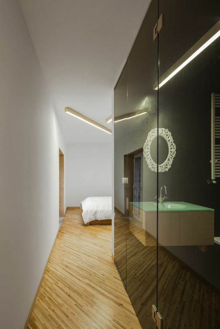 Une des chambres avec sa salle d’eau incorporée de cette jolie demeure chambre moderne cabine de douche transparente