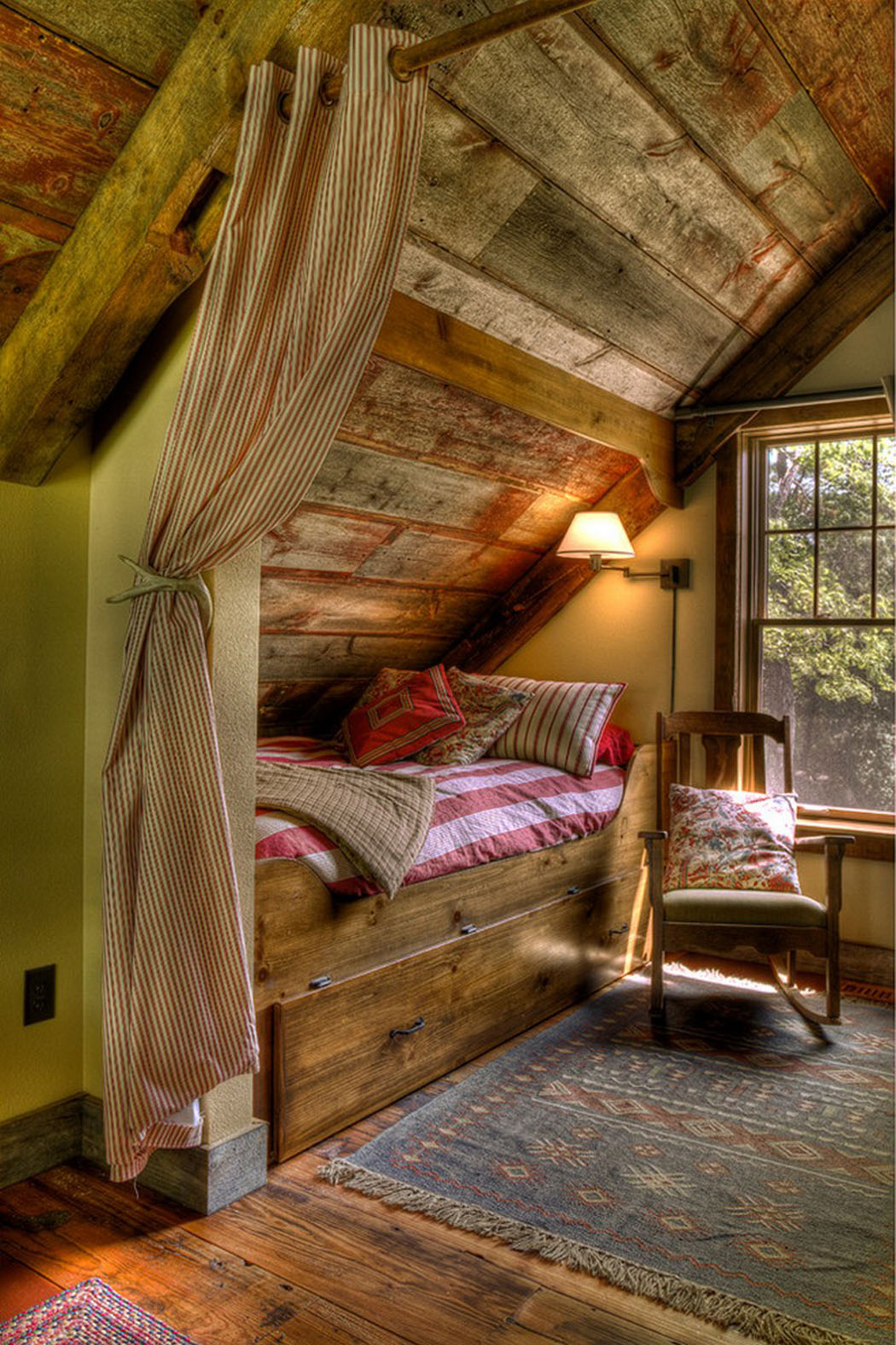 Une petite chambre d’amis aménagée dans les combles de cette maison de vacances rustique aménagement chambre sous toit en bois