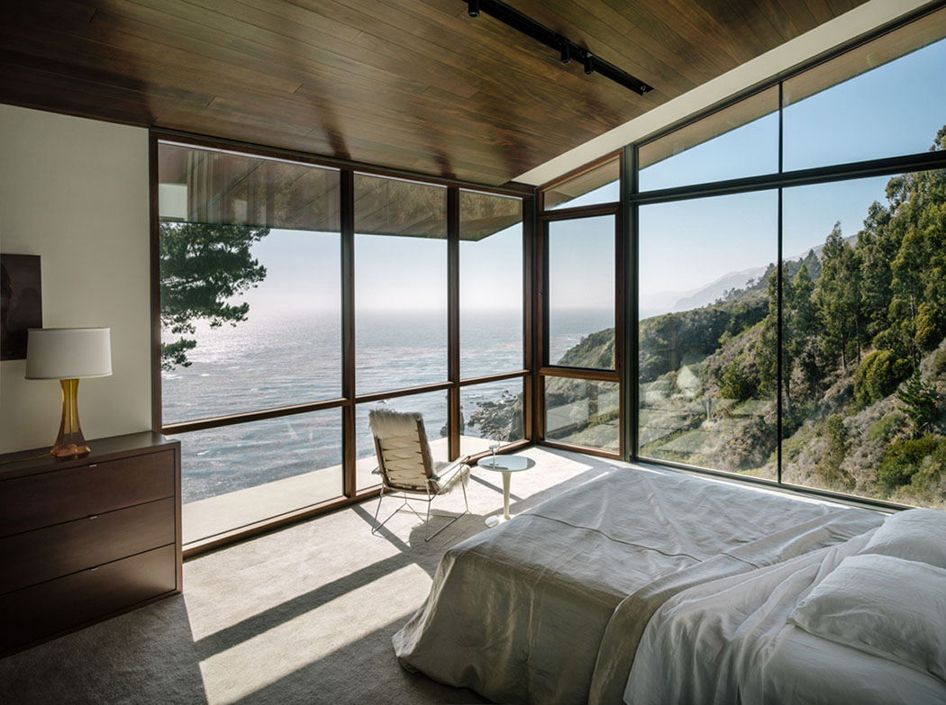 Une des trois suites dans cette belle maison contemporaine offrant une splendide vue sur l’eau chambre à coucher ameublement minimaliste belle vue panoramique