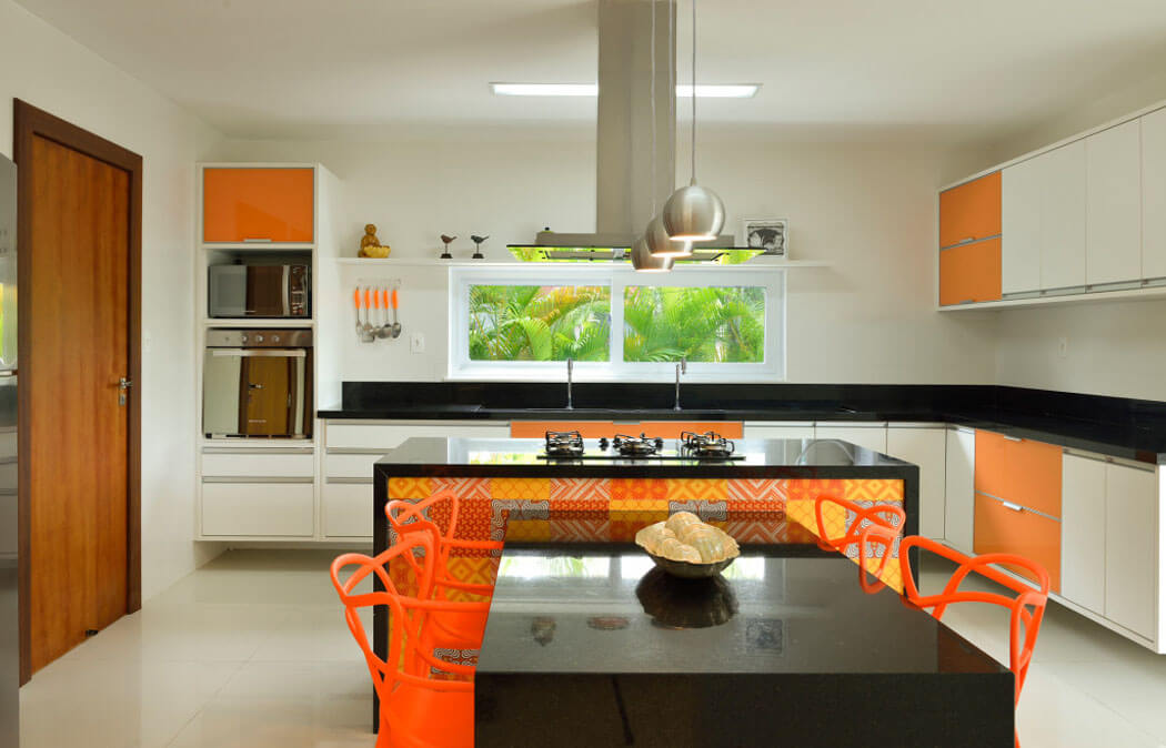 La cuisine de la maison de vacances est séparée et arbore des couleurs vives et chaleureuses cuisine aménagée orange moderne placards