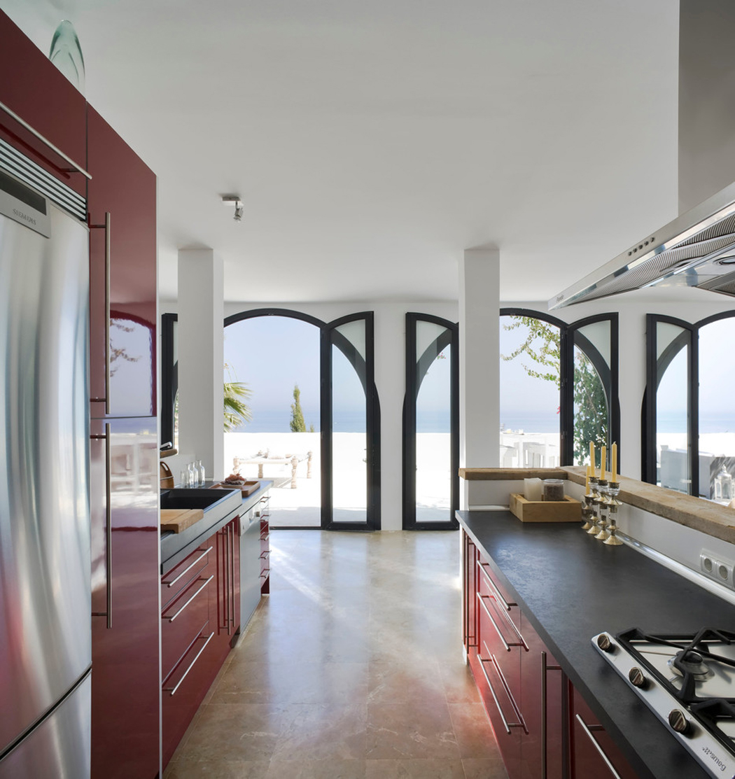 La cuisine ouverte sur la salle à manger, le séjour et les espaces extérieurs de la villa cuisine américaine équipée de luxe