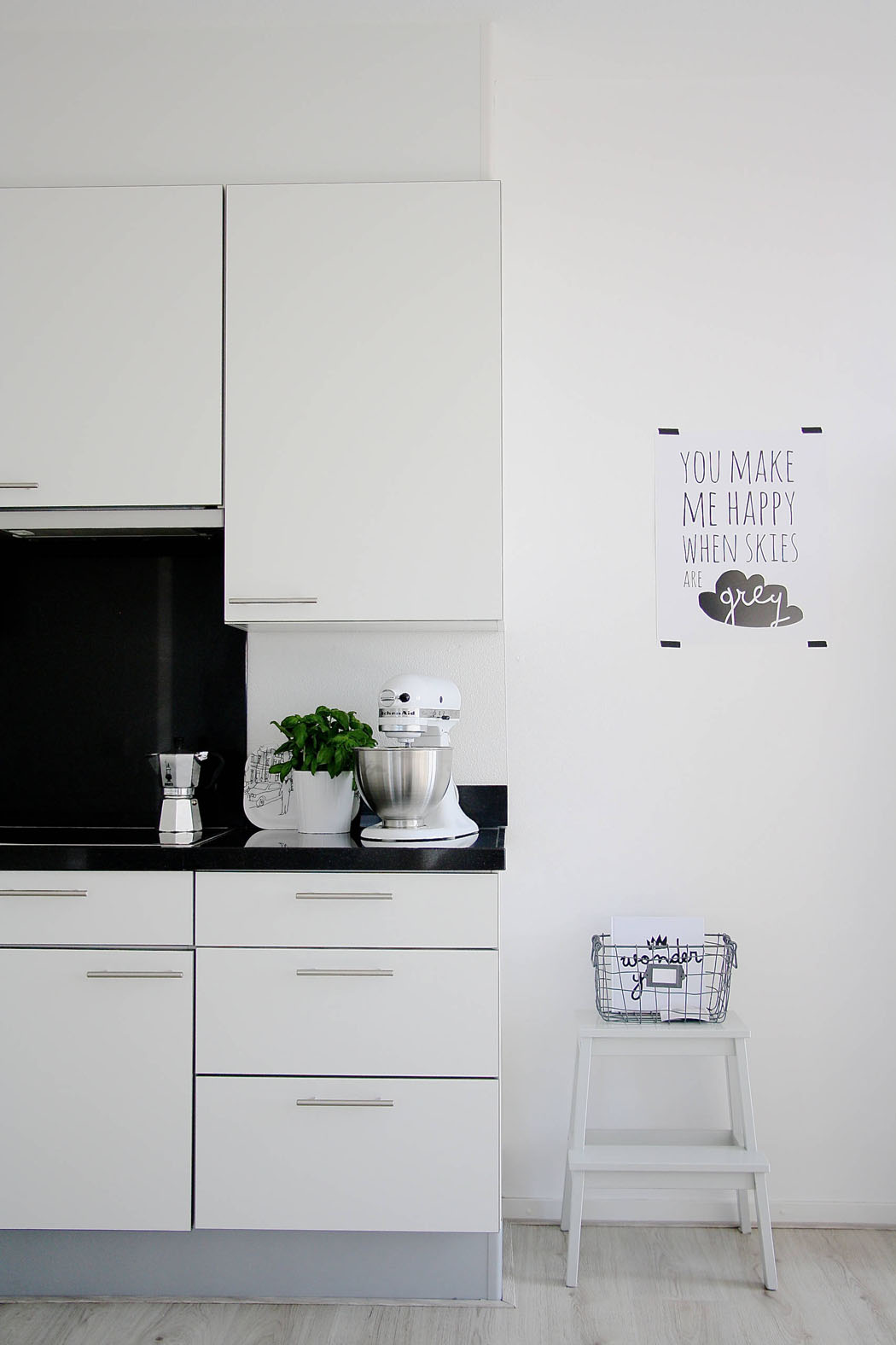 Les couleurs blanc et gris anthracite créent un contraste prononcé dans la déco de ce joli appartement cuisine aménagement simple placards blancs