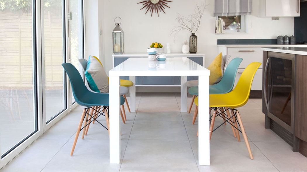 Petite salle à manger en blanc meublée des chaises Eames de différentes couleurs pastel salle à manger chaise eames