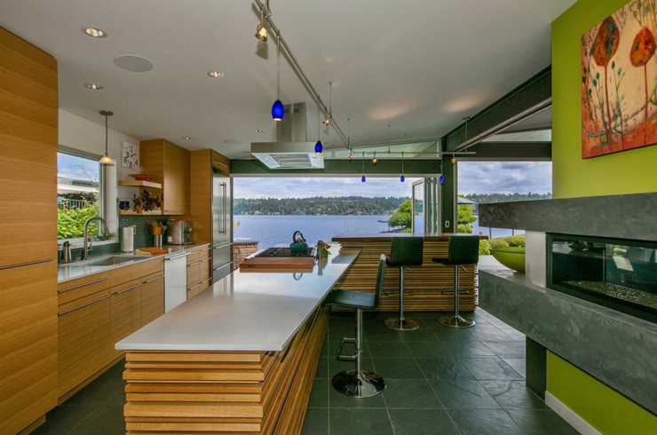 Une cuisine ouverte et remodelée aux placards en bois vue sur lac maison de ville