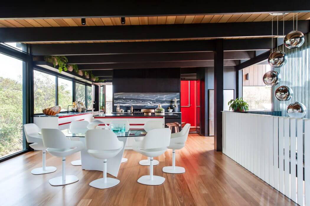 La cuisine ouverte et claire donne sur la salle à manger meublée de façon rétro chic décoration design moderne et tendance maison familiale