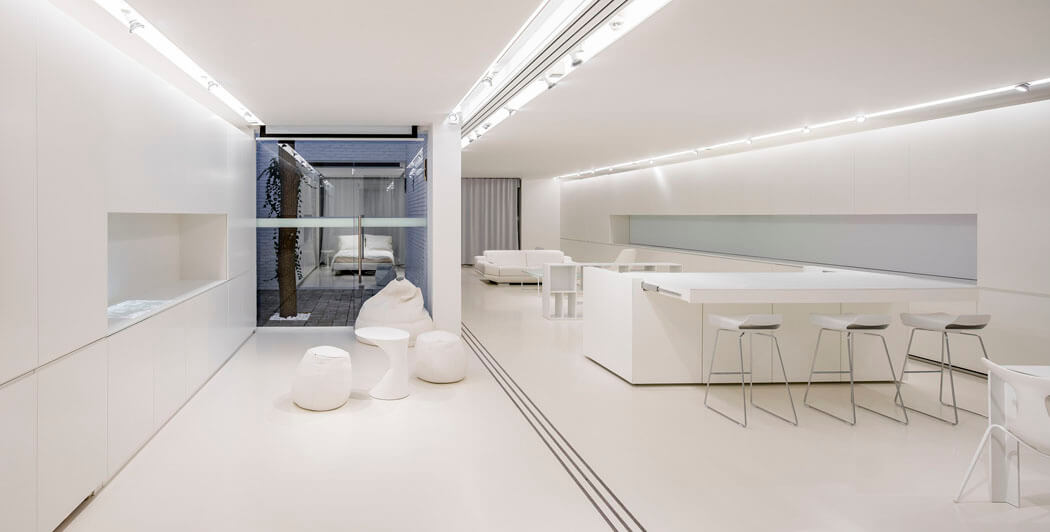 Lorsque les fameux panneaux sont tirés l’intérieur change d’ambiance pour souligner le blanc prédominant intérieur futuriste design minimaliste appartement citadin