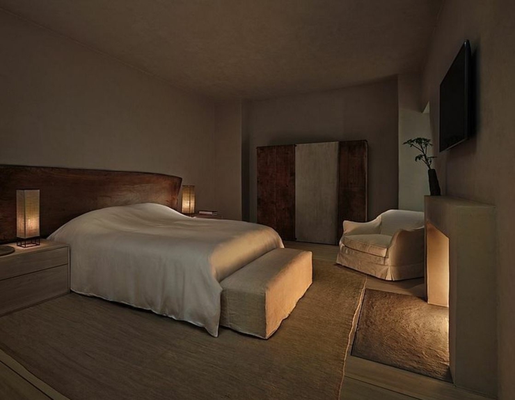 Chambre principale la nuit tombée avec la cheminée allumée chambre à coucher style industriel
