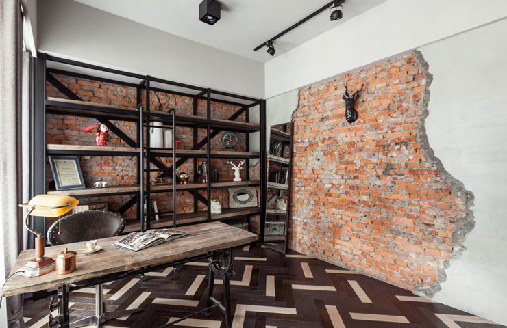 Le bureau séparé du séjour par une paroi transparente en verre Briques visibles murs appartement moderne