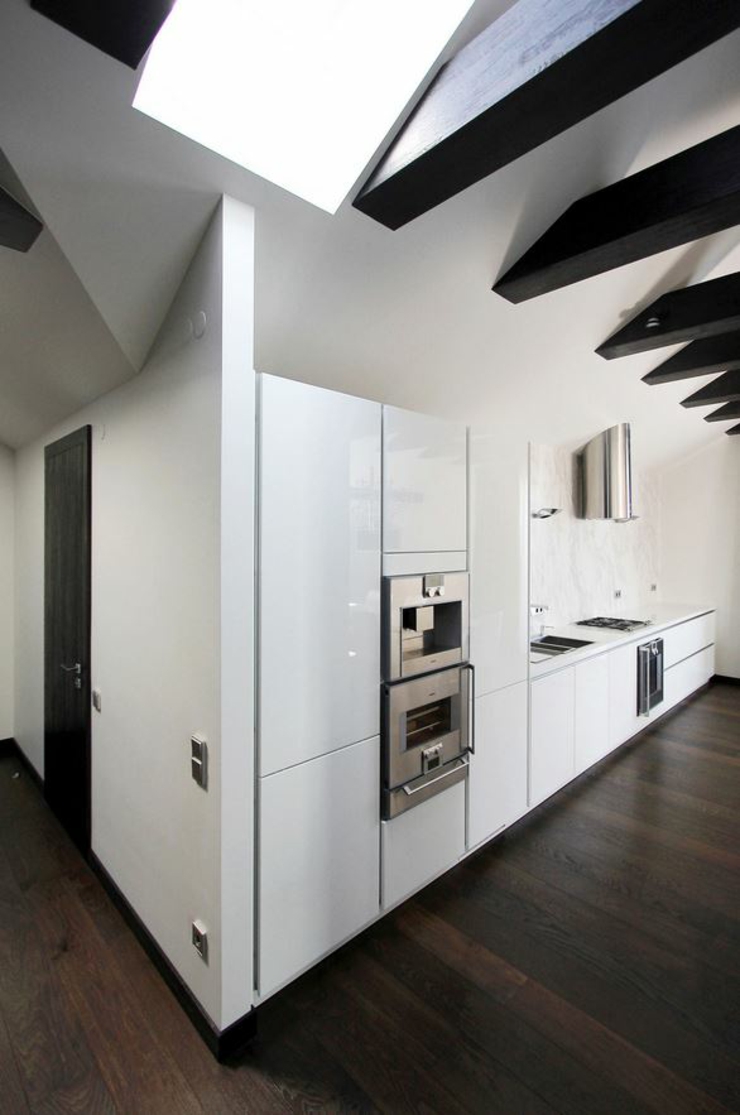 A côté de l’entrée se trouve la cuisine américaine en blanc cuisine ouverte aménagée en blanc