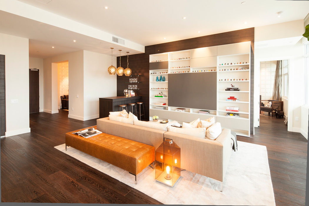 La pièce principale de cet appartement moderne meublée de façon sobre et tendance mobilier salon grand canapé d'angle design luxe