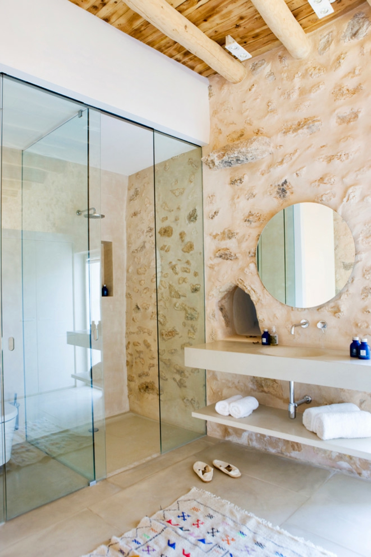 Grande et luxueuse salle de douche à l’inspiration rustique grâce aux murs en pierre salle de bain rustique