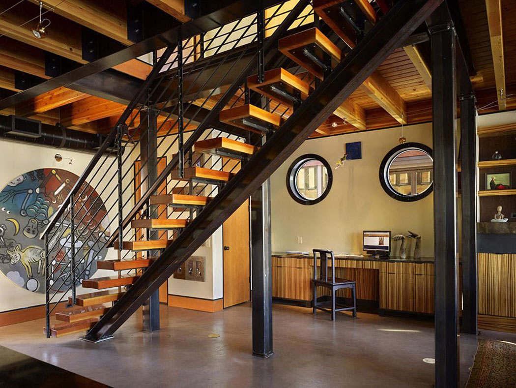Un coin bureau est aménagé sous l’escalier intérieur qui mène à l’étage des chambres intérieur éclectique moderne et spacieux