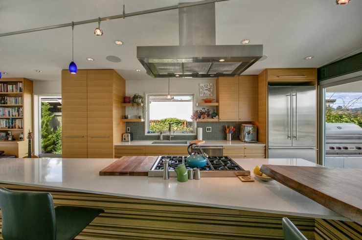 Nombreuses fenêtres et baies vitrées pour rendre l’intérieur lumineux placards multiples cuisine moderne