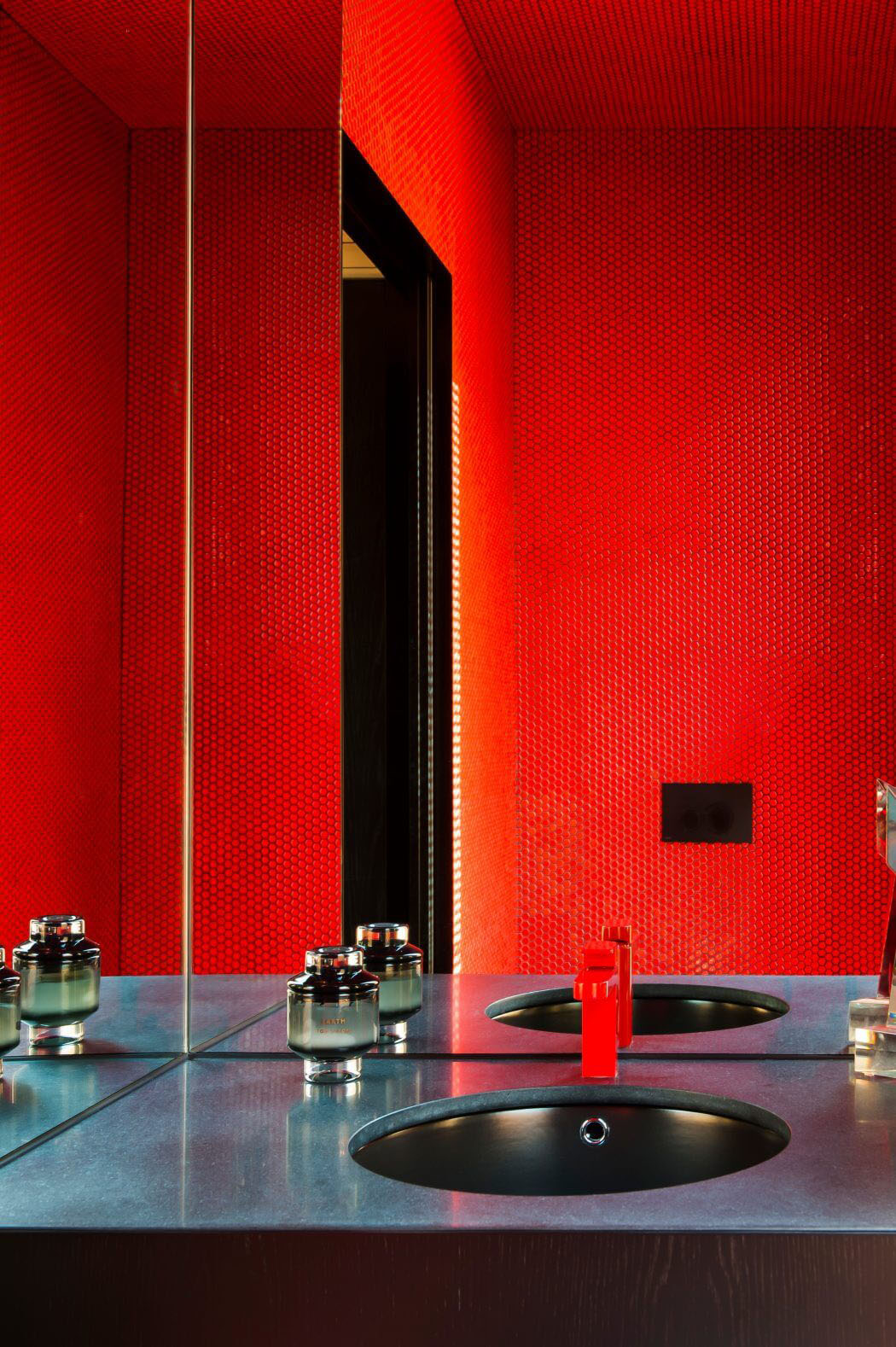 Les toilettes situées derrière la cuisine prolongent le fil des teintes rouge & noir intérieur design moderne toilettes en rouge