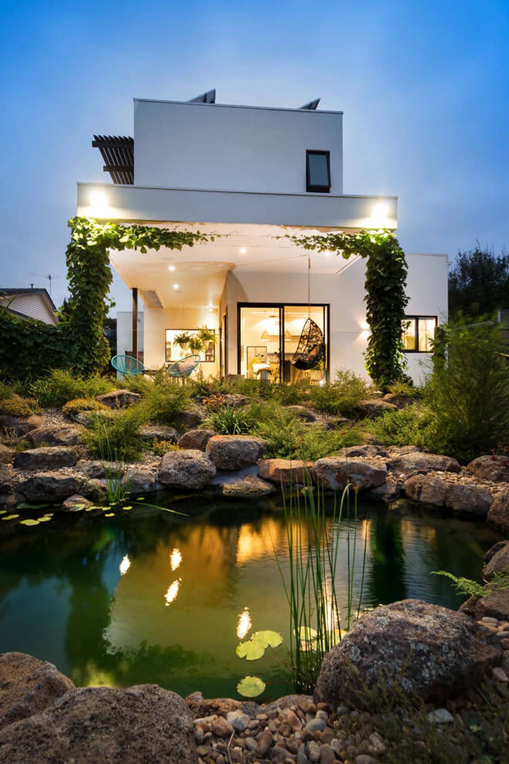 La vue nocturne de cette maison contemporaine depuis l’arrière jardin et le mini lac artificiel aménagement outdoor lac artificiel jardin