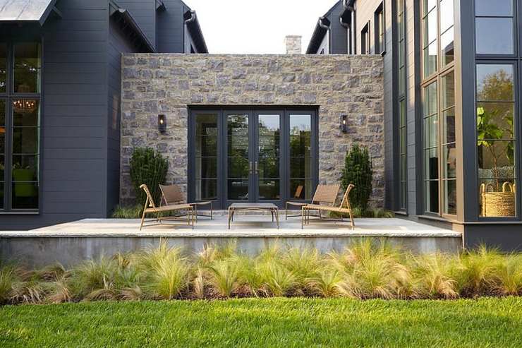 Petite terrasse pour se détendre située de l’autre côté de la résidence façade maison de charme rustique prestige