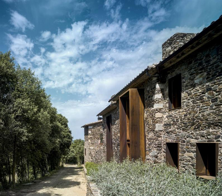 Le bois et la pierre des murs extérieurs de cette ancienne ferme catalane La vue extérieure de cette maison ancienne rénovée