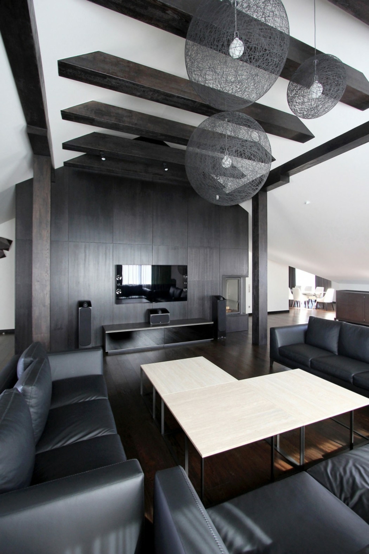 Poutres apparentes en bois foncé assorties avec le parquet et le mobilier séjour design intérieur blanc et noir