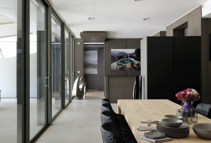 Intérieur sombre mais élégant de cette maison avec piscine salle à manger chaises noires