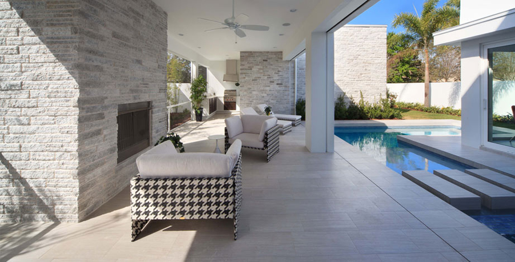 Le patio à côté de la piscine de cette belle maison d’architecte Terrasse couverte de cette belle demeure moderne