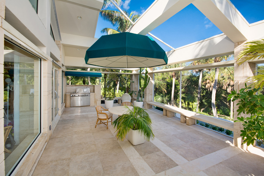 Belle véranda vitrée faisant office de cuisine d’été ou de jardin intérieur propriété de prestige patio véranda