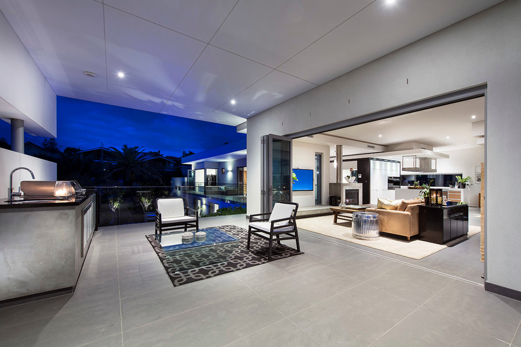 La cuisine ouverte donne un accès vers un patio au mobilier minimaliste patio couvert avec superbe vue