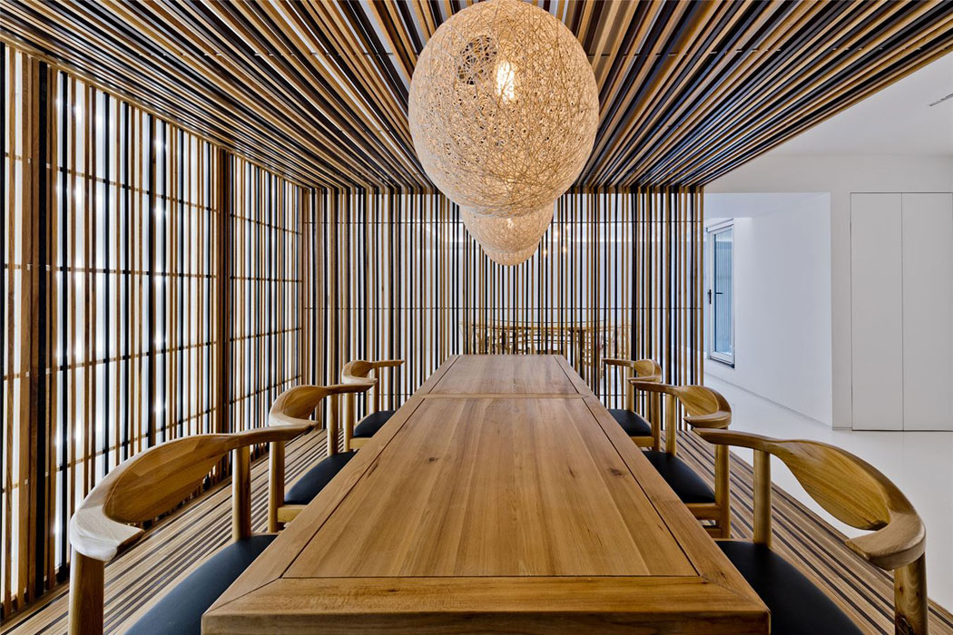 Au même niveau se trouve une petite salle à manger meublée d’une table, six chaises et trois suspensions tendances meubles en chêne ameublement design tendance