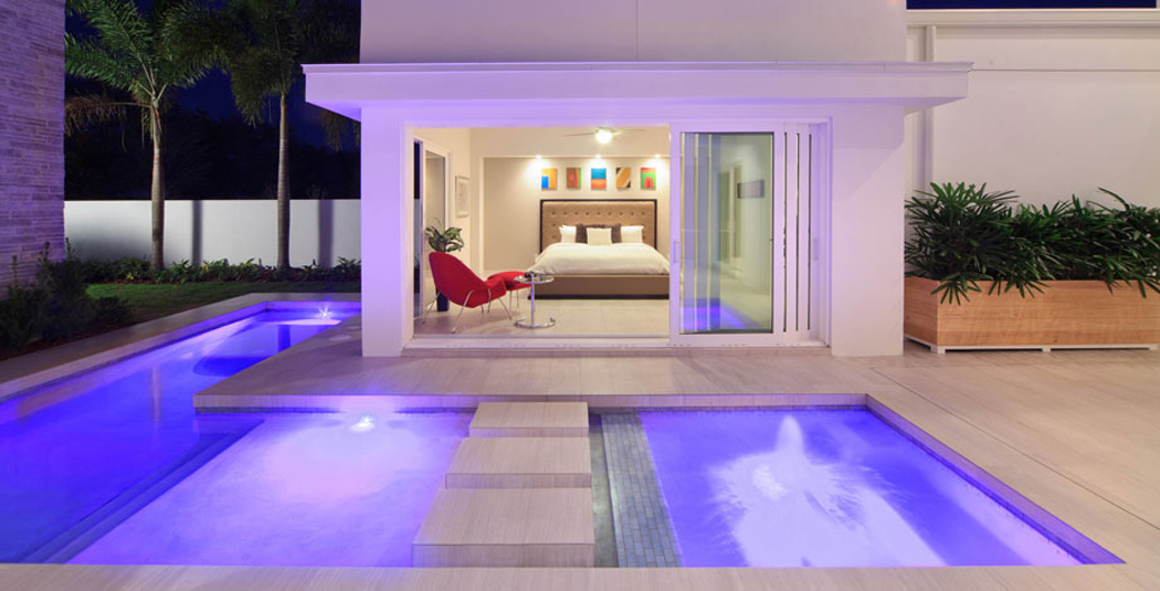 La chambre principale vue dans la nuit depuis l’extérieur Suite parentale donnant sur la piscine
