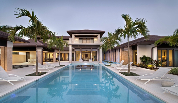 La piscine extérieure avec la terrasse tout autour et les chaises longues belle résidence de vacances exotiques
