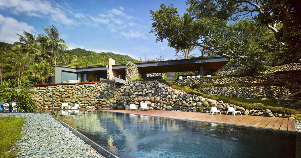 La façade de cette résidence exotique vue depuis le troisième - le plus bas niveau du terrain grande piscine extérieure avec vue mer