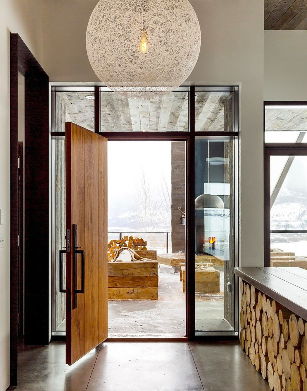 La porte d’entrée en bois massif et le sol en béton coulé de cette maison rustique maison originale de vacances hiver été
