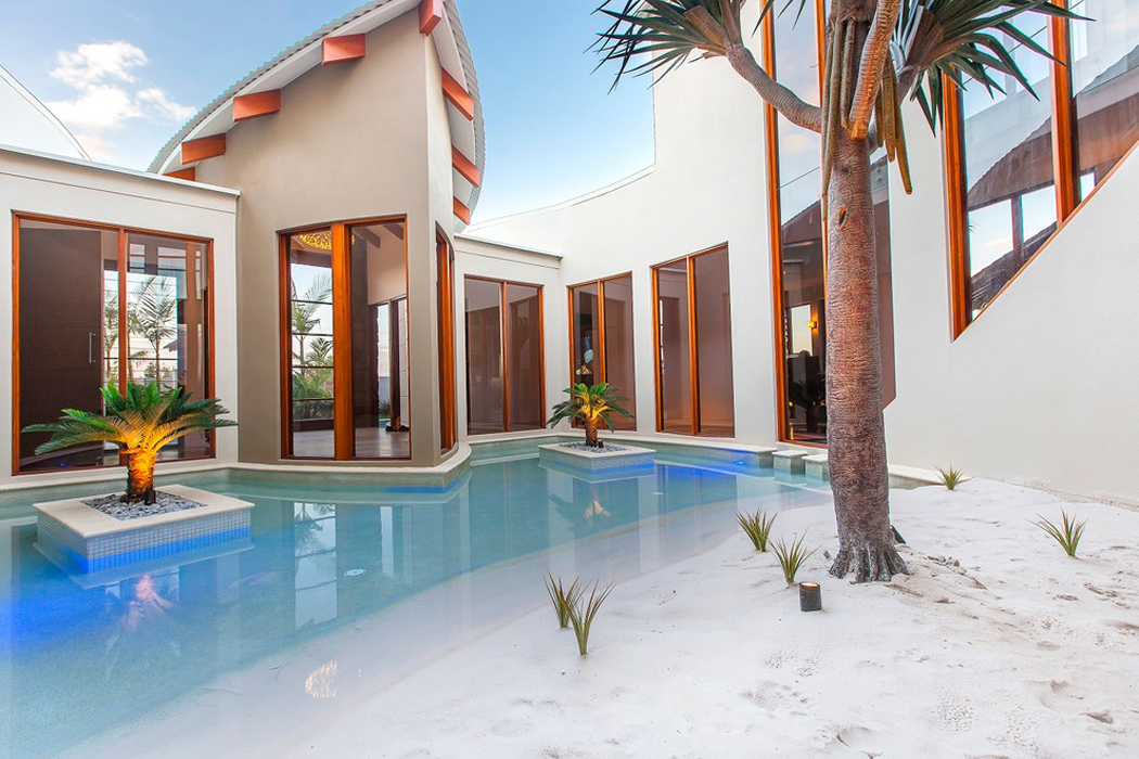 Superbe piscine de luxe aux ilots aménagés et aux palmiers décoratifs Grande et originale piscine design luxe