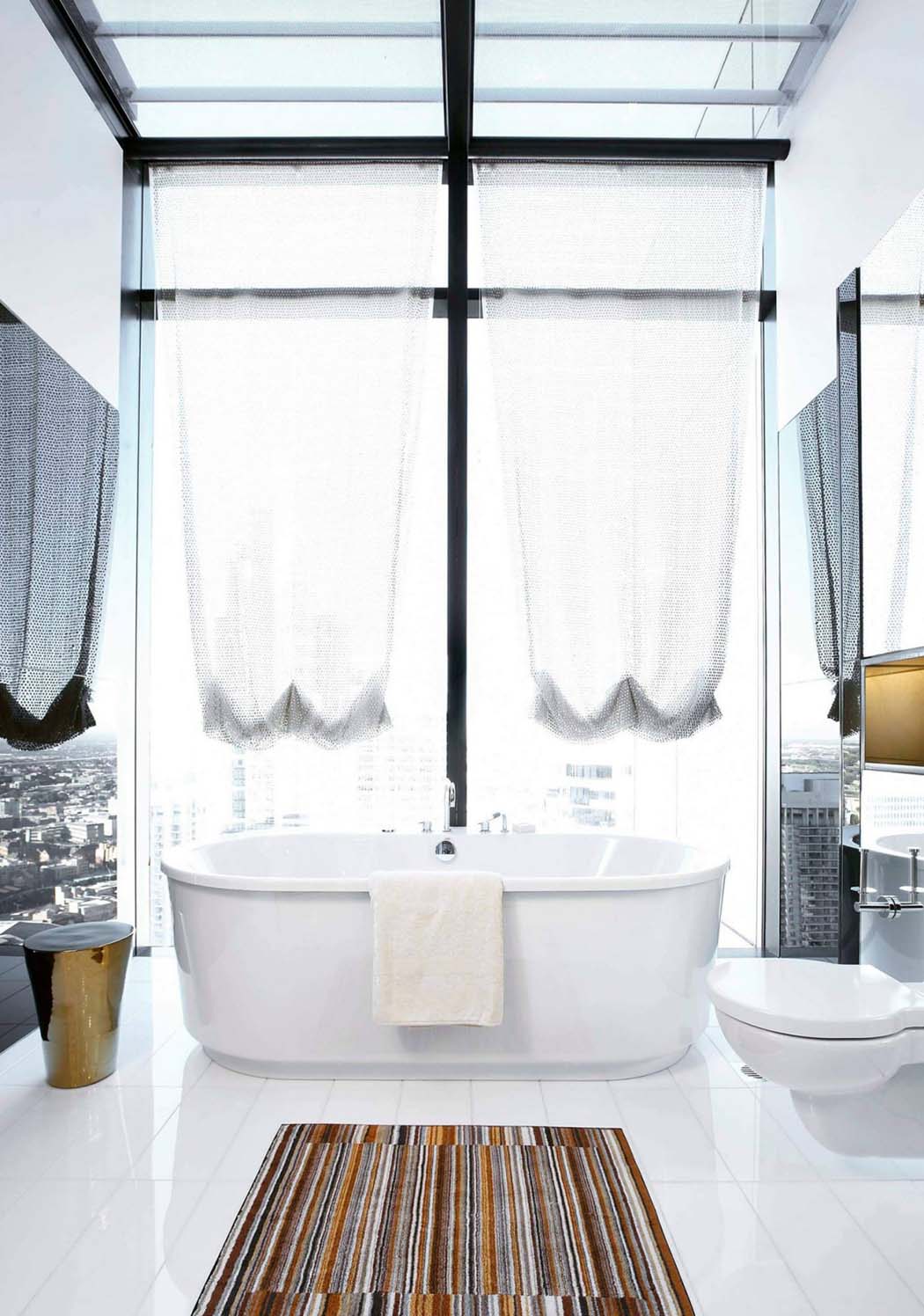 Une des salles de bains privatives des chambres offrant une vue impressionnante sur le paysage de la ville salle de bain aménagement spacieux luxe
