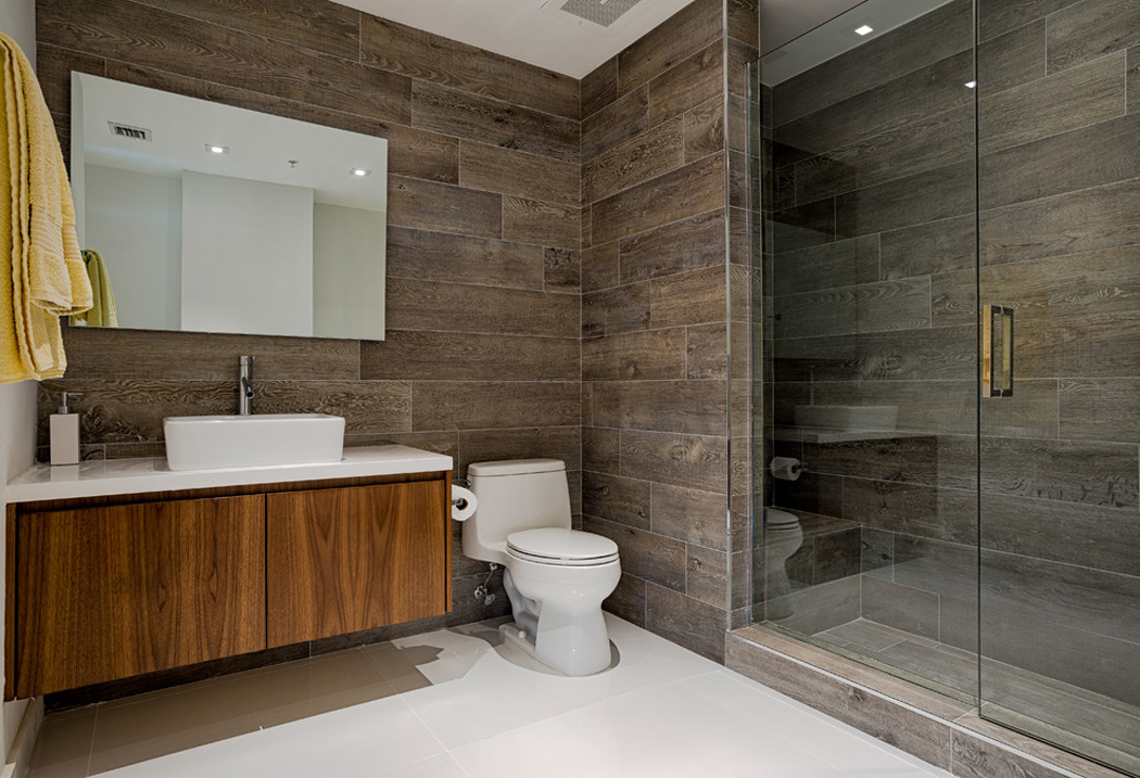 Salle de douche au design sombre contrastant avec le reste de la résidence salle de bains en blanc et marron
