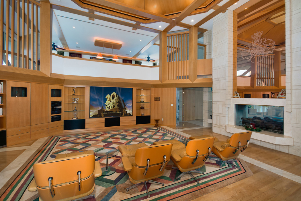 Spacieuse salle de projection privée aux boiseries et un côté légèrement retro home cinéma propriété privée de luxe