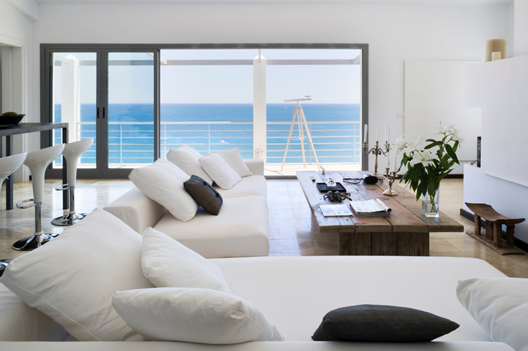 Coin salon aux canapés modernes et confortable en blanc Salon au baie vitrée avec vue sur mer