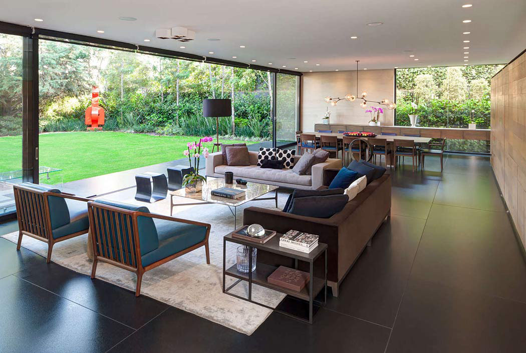 Le séjour principal et salle à manger spacieuse aux grandes baies vitrées donnant sur le jardin ameublement mobilier design luxe séjour salle à manger