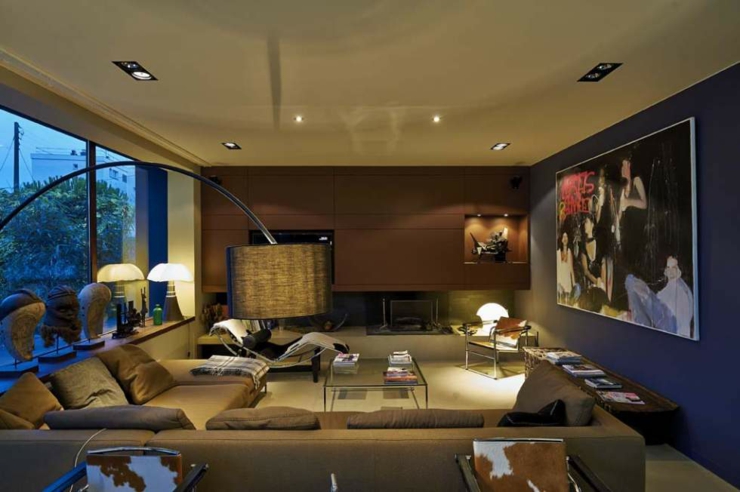 Une ambiance aux lumières tamisées et grand canapé d’angle relaxant intérieur cozy résidence de ville