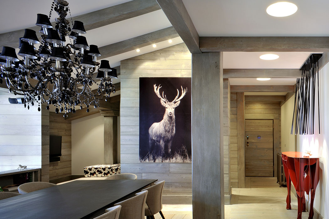 Un appartement de vacances aménagé sous le toit au design chaleureux et élégant pièce principale poutres apparentes chalet de montagne