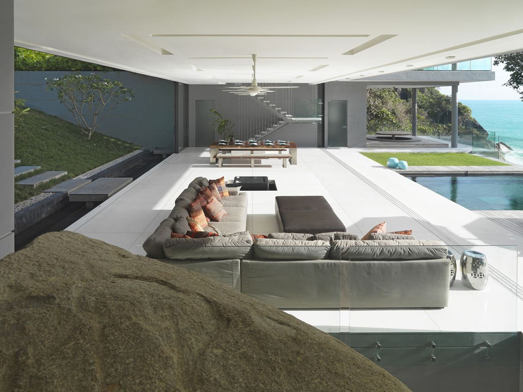 Un ameublement très minimaliste mais luxueux mettant en valeur les grandes espaces de vie de cette villa de rêve salon séjour résidence de grand standing phuket