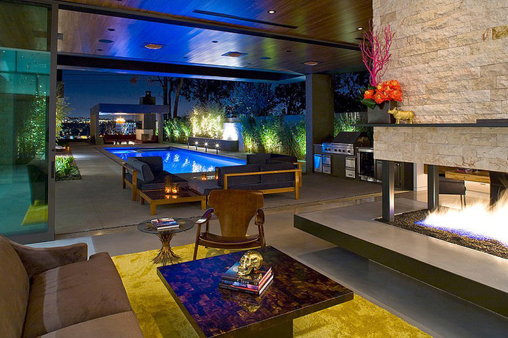 Séjour et vue de nuit sur la piscine de la maison d’architecte intérieur moderne et contemporain très spacieux